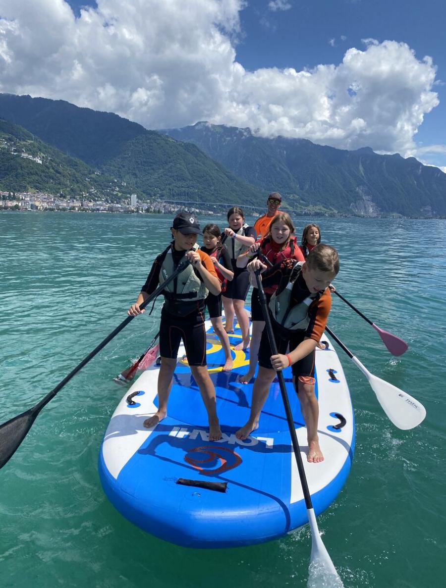 Students paddleboarding on a lake during an Inspired Education Group international summer camp