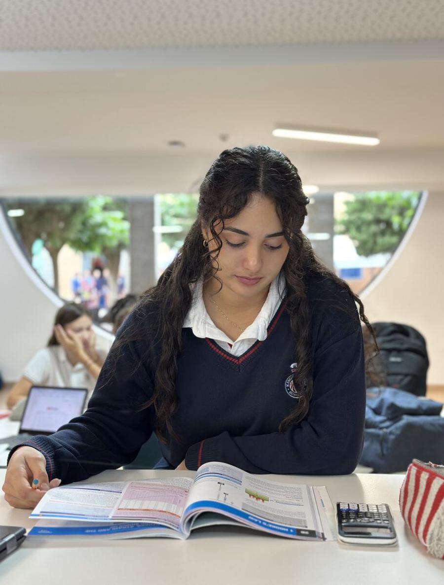 Estudiante de Secundaria estudiando con un libro de texto y una calculadora en King's College, Alicante