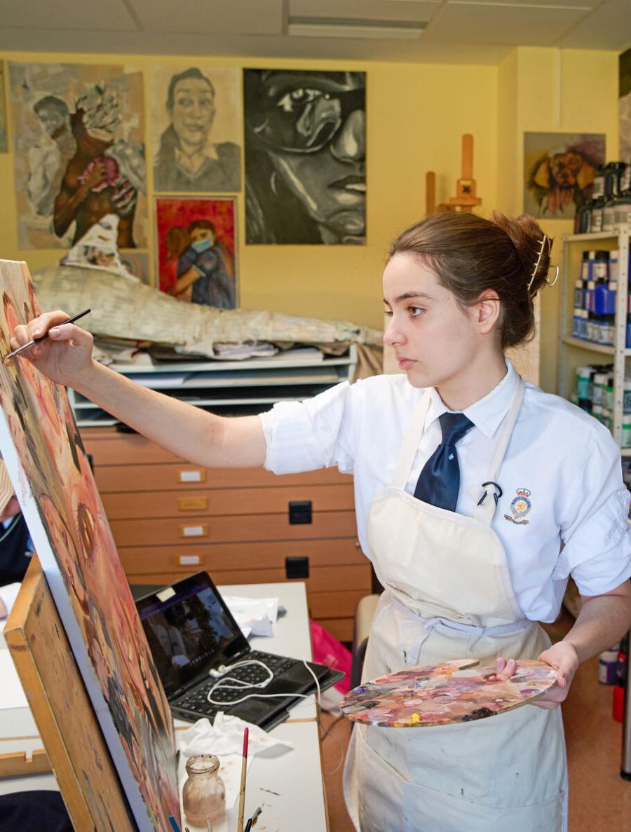 Estudiante de Secundaria pintando en un caballete en el aula de arte en King's College, Alicante