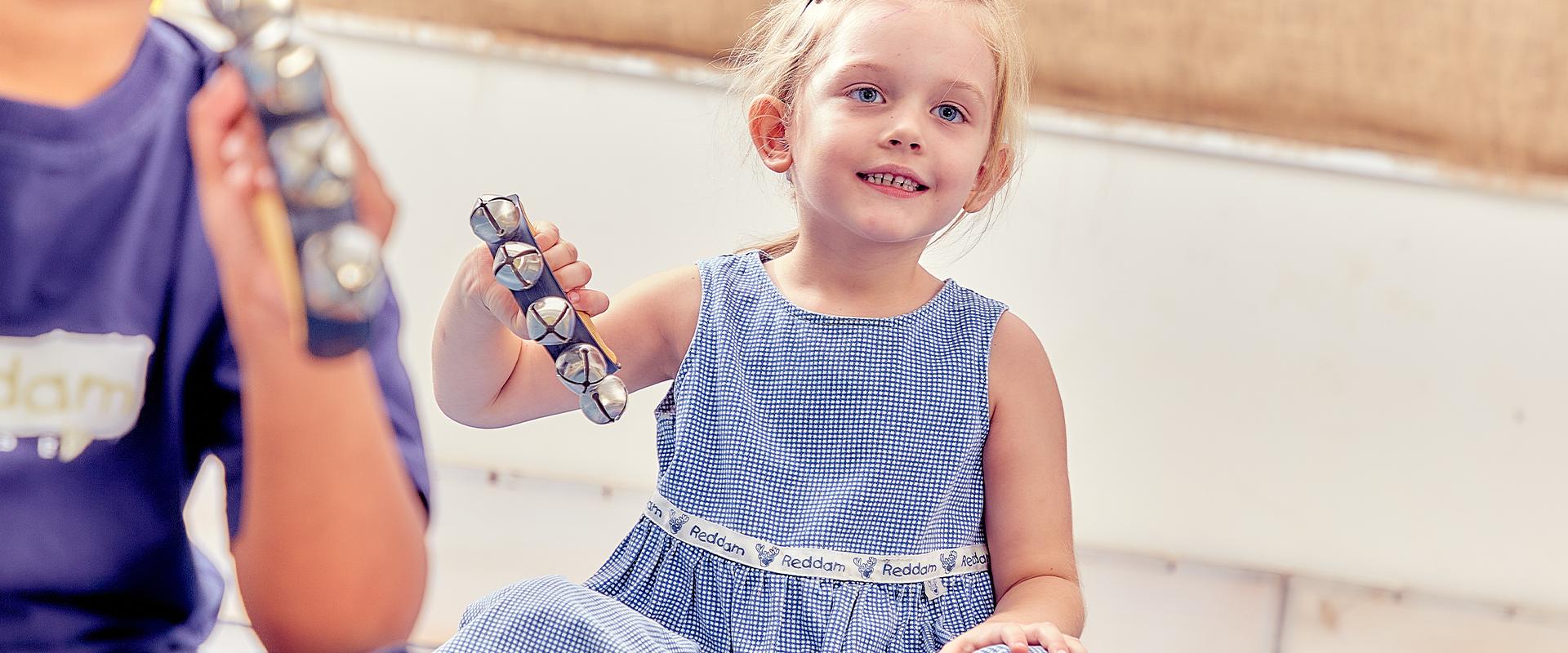 Girl holding a musical hand instrument