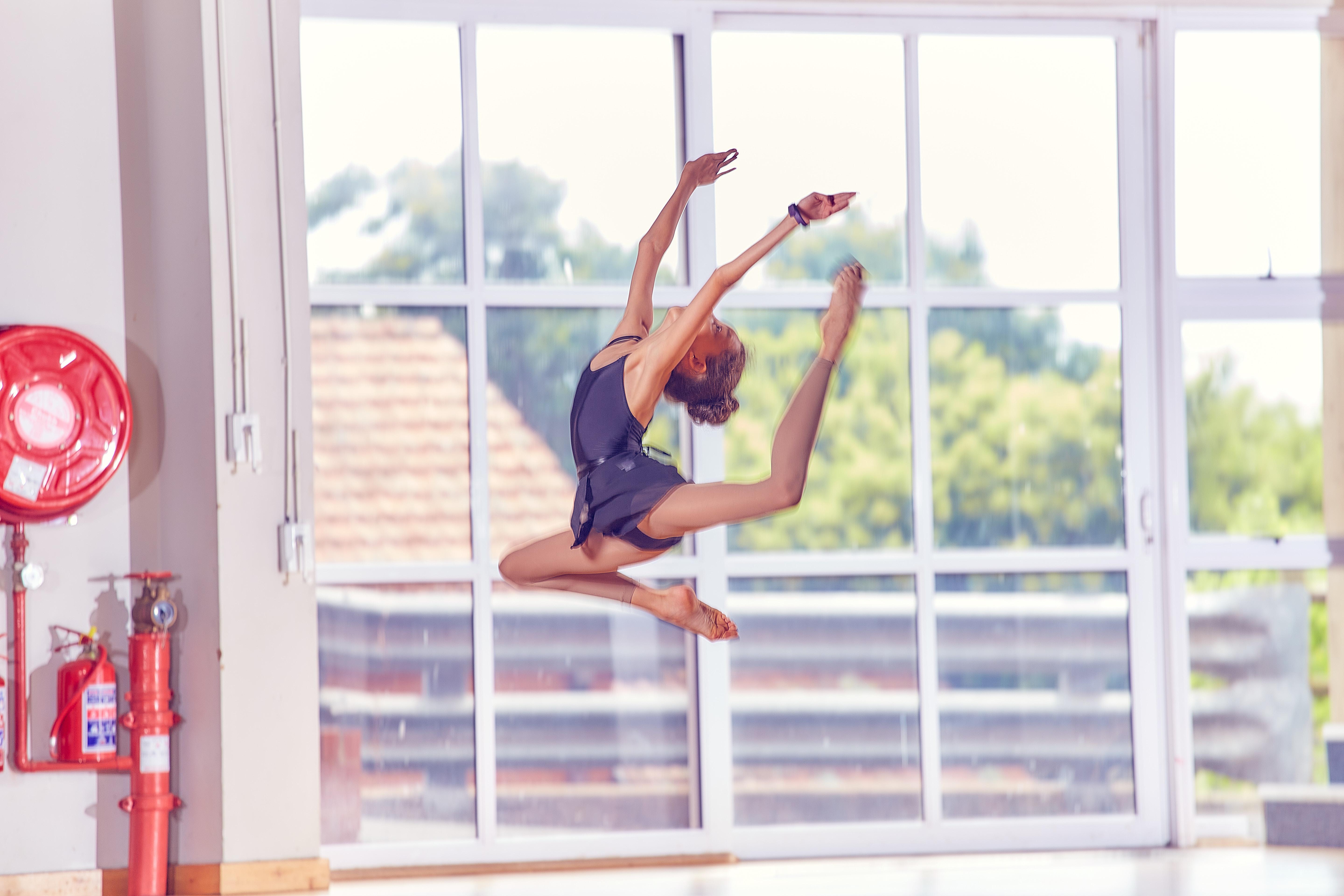 Young girl leaping in the air in an acrobatic pose