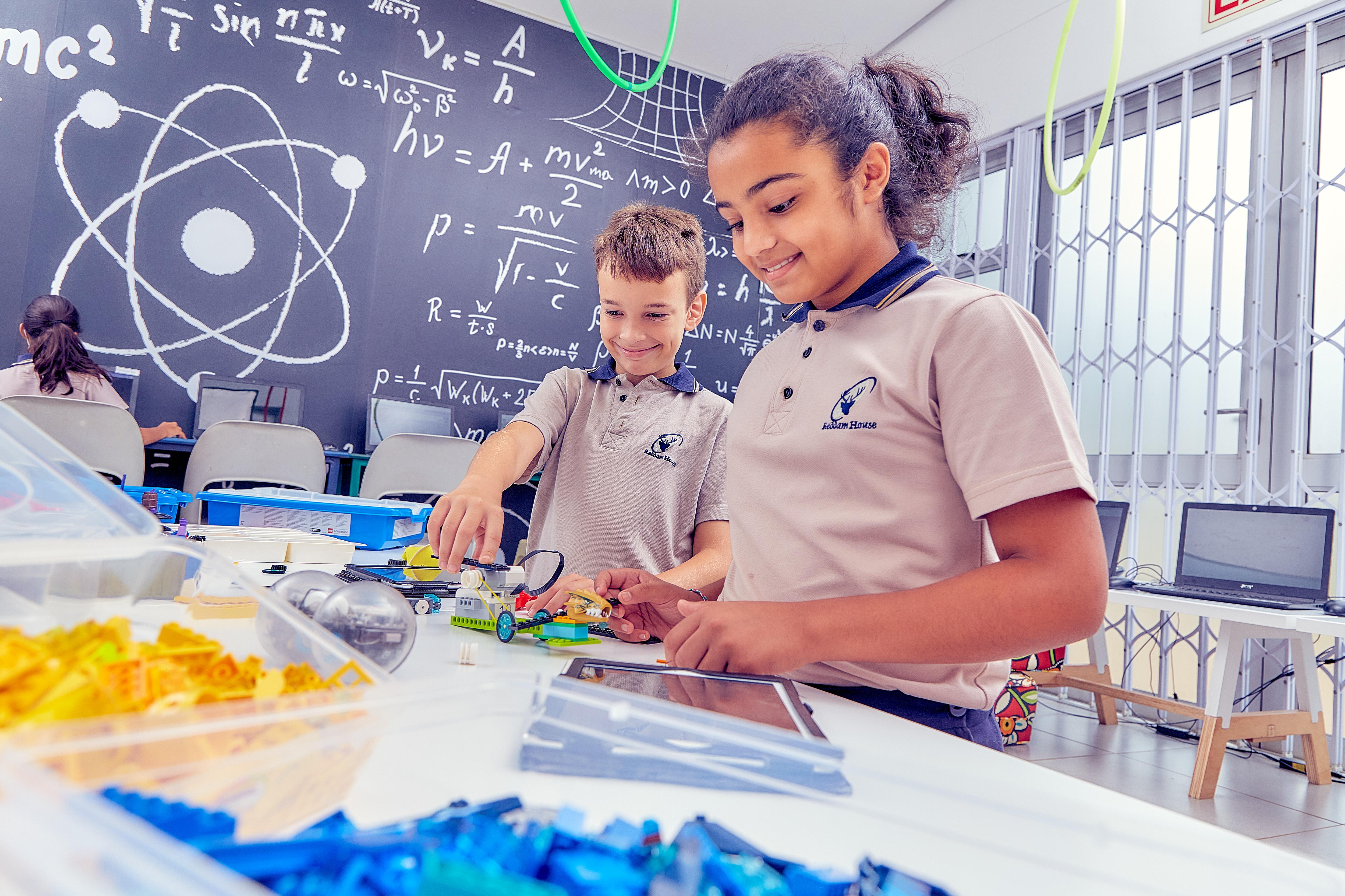Two students building a mechnical device