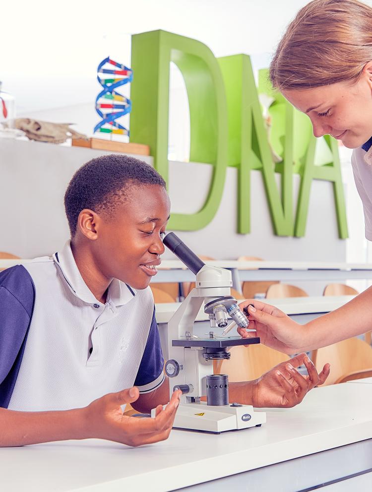 Two students looking at a microscope