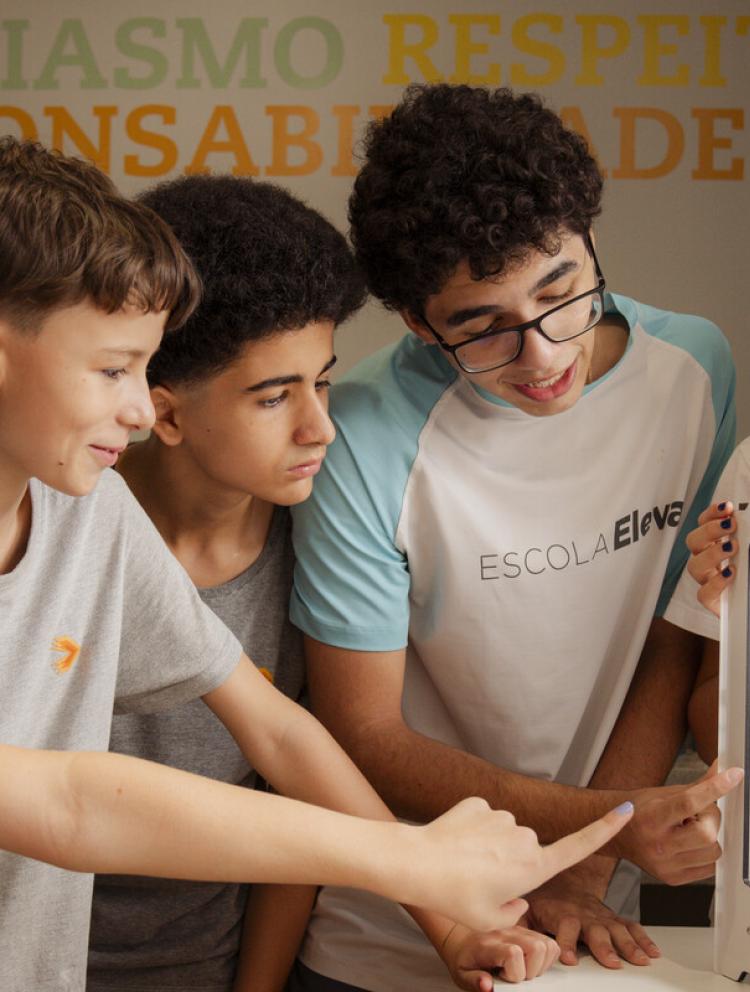 Alunos da Escola Eleva Brasília, uma escola internacional bilíngue na Asa Sul, trabalhando juntos em um laptop