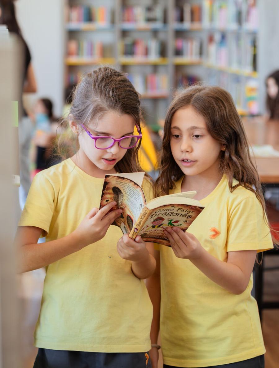 Alunos do Ensino Fundamental I lendo juntos na biblioteca da Escola Eleva Brasília