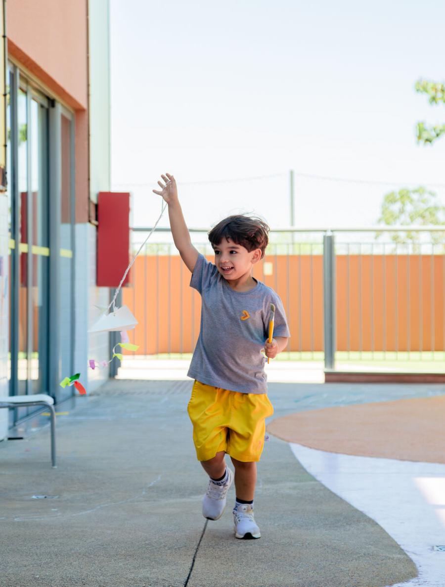 Criança da Educação Infantil empinando pipa na Escola Eleva Brasília, na Asa Sul