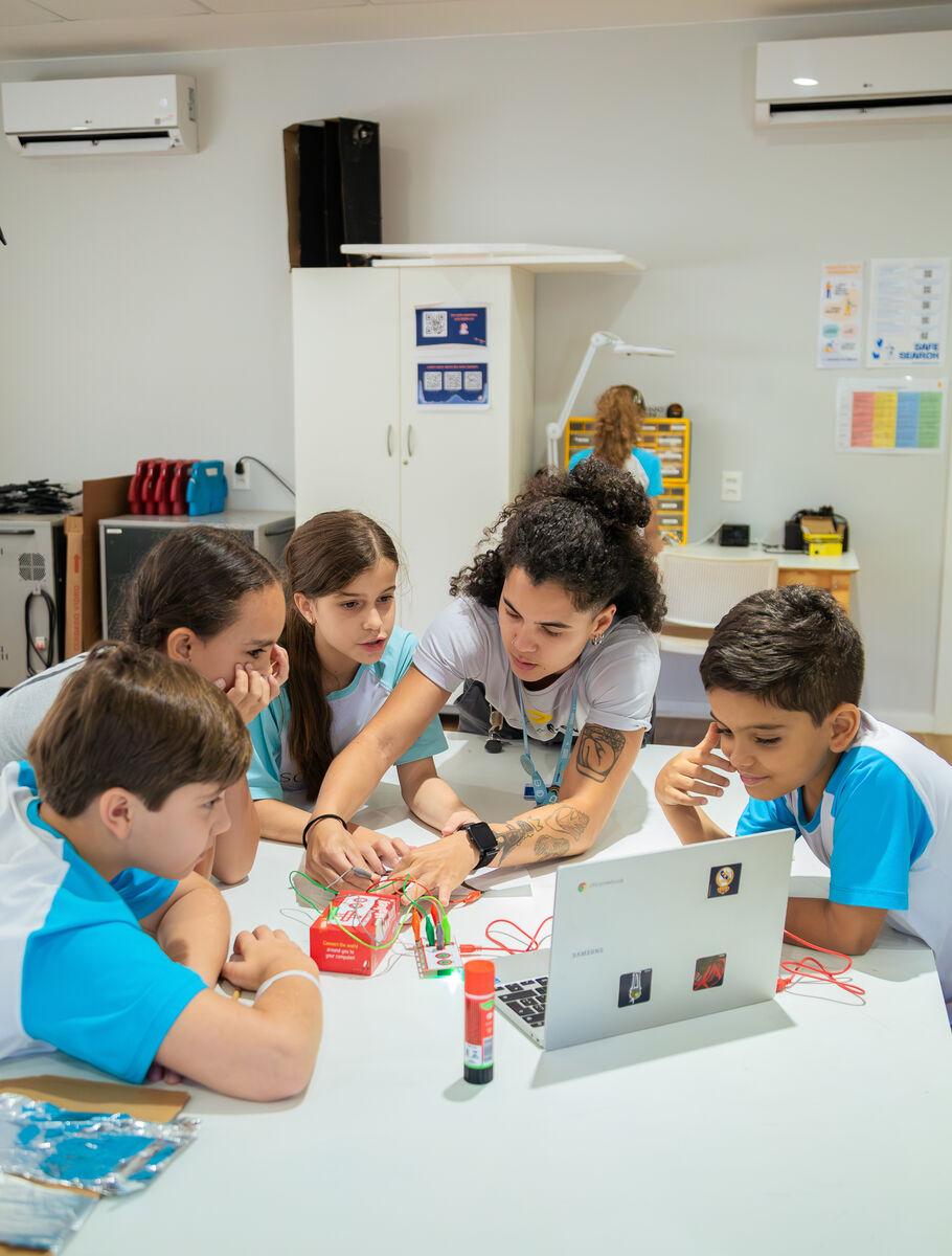 Alunos e professora desenvolvendo um projeto de robótica na Escola Eleva Brasília, na Asa Sul