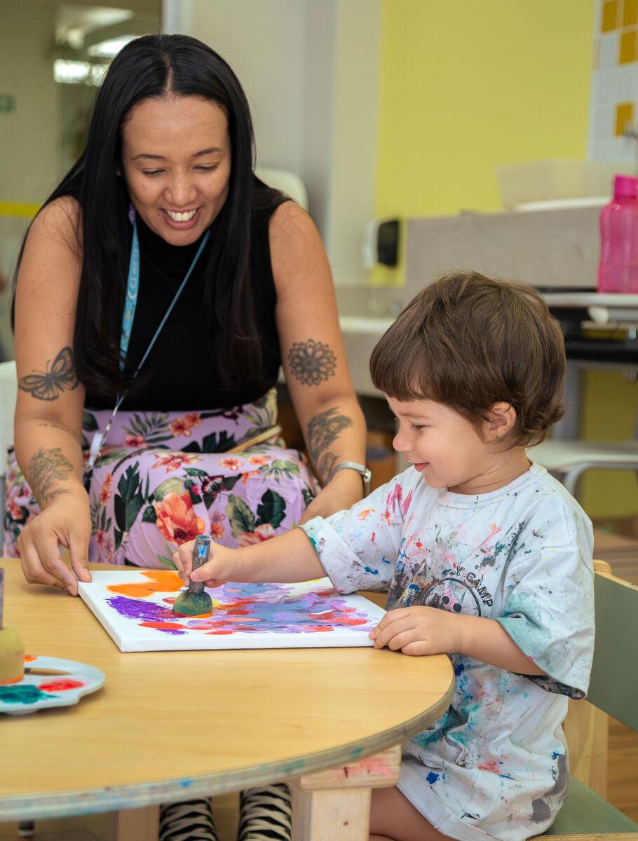 Criança da Educação Infantil pintando na Escola Eleva Brasília, na Asa Sul
