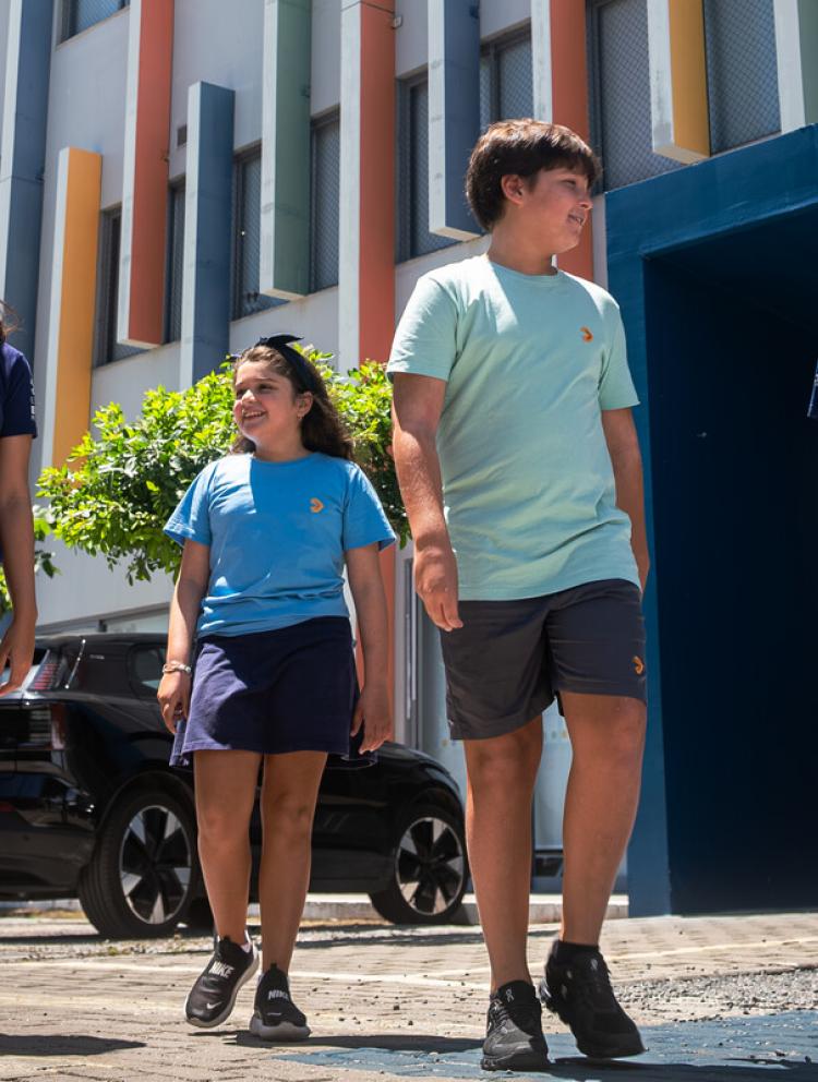 Alunos caminhando em frente ao prédio do campus da Escola Eleva Recife, que integra a rede global Inspired Education