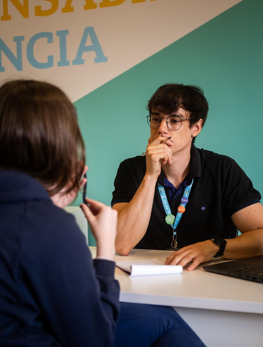 Membro da equipe orientando um aluno individualmente na Escola Eleva Recife