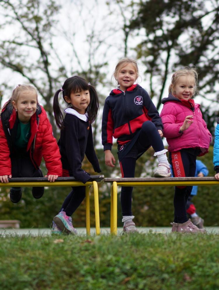Kindergarten students sitting on bench outside