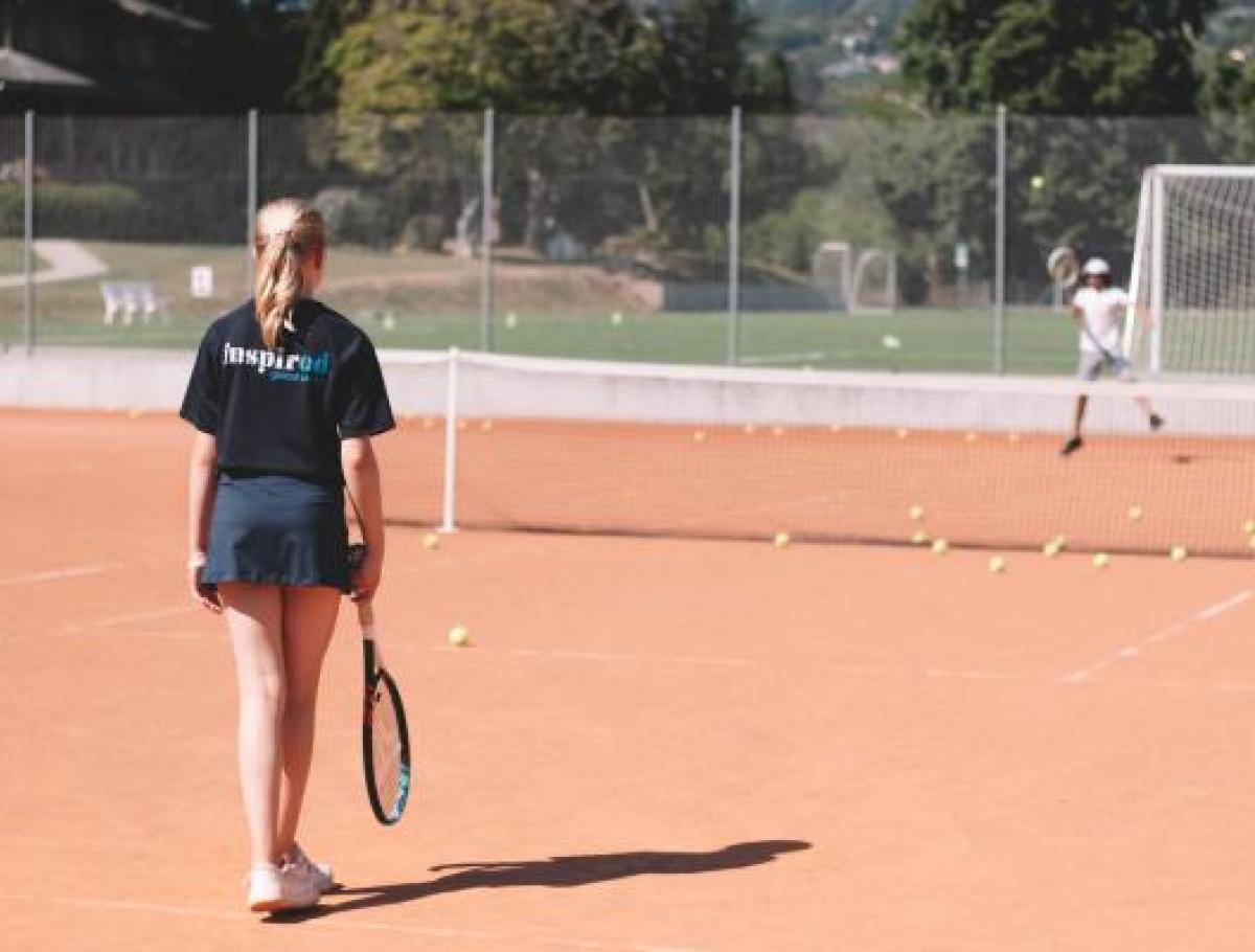 summer camp student playing tennis