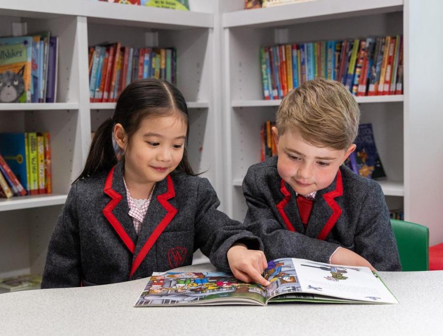 Students reading a magazine together in the library