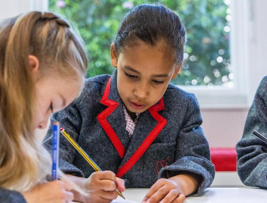 Female student in Wetherby uniform writing at a desk