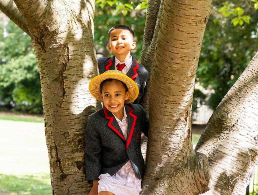 Two pupils smiling in the fork of a silver birch tree